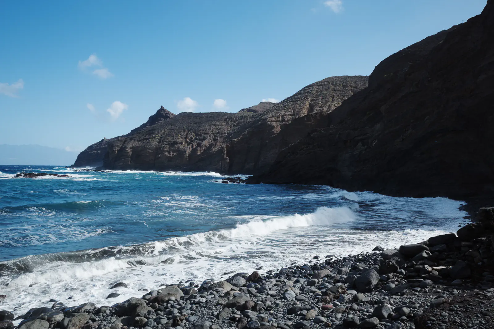 Hier treffen die Wellen auf den felsigen Strand.