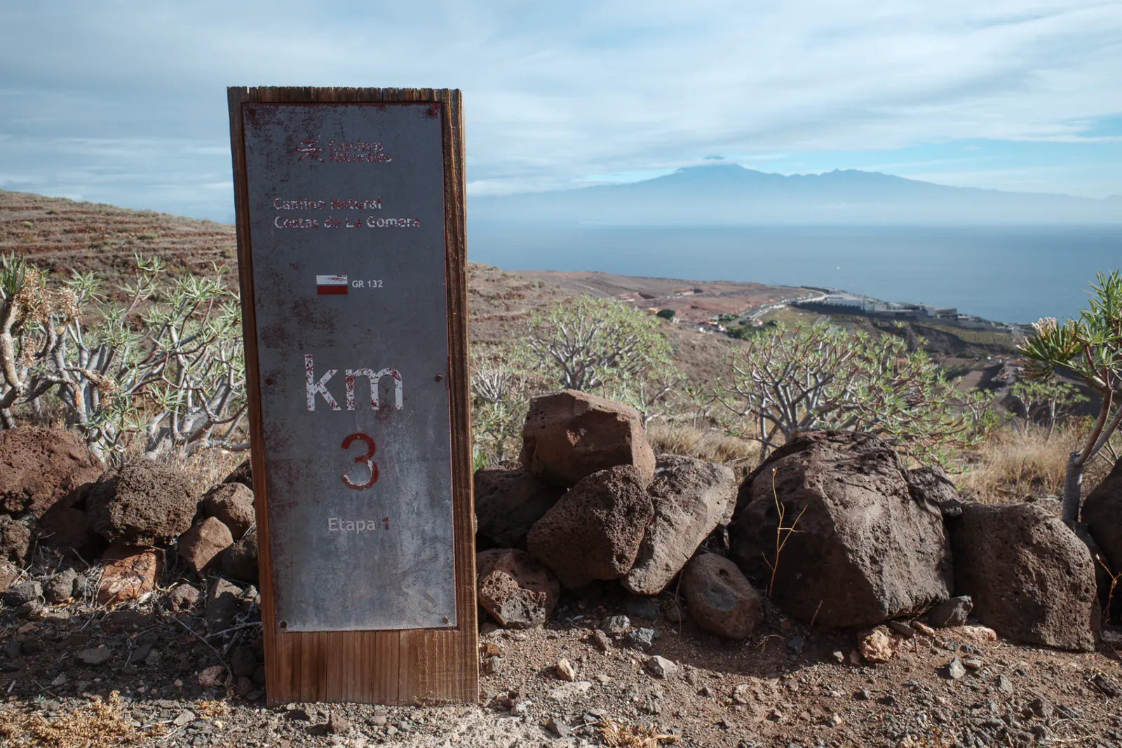 Eine Kilometermarkierung des GR 131 und Teneriffa im Hintergrund